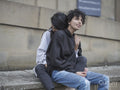 Smiling female couple cuddling on wall