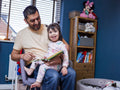 Father reading book to daughter