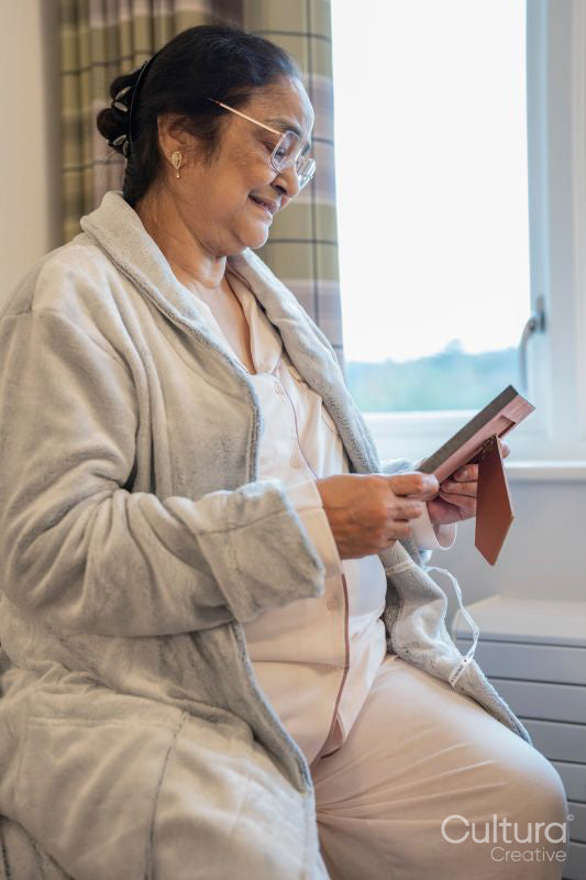 Senior lady sitting with photography at nursing home