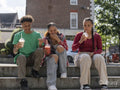 Friends laughing while drinking smoothies on steps