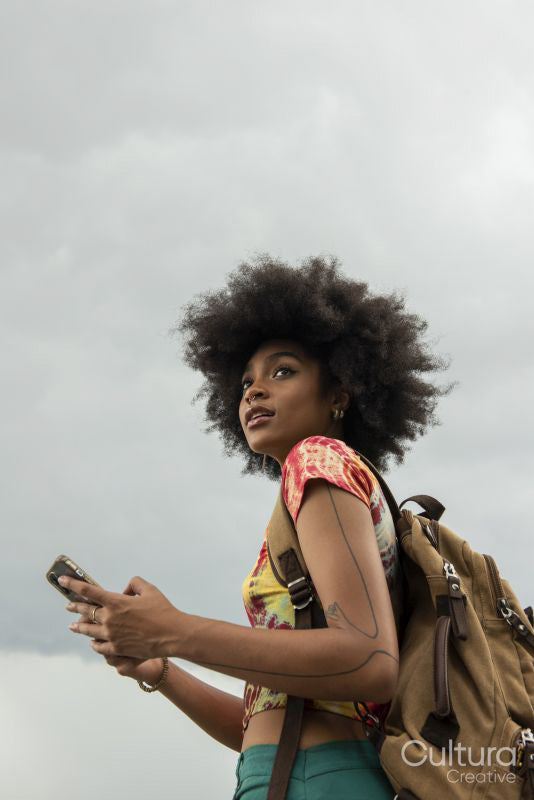 Young woman with backpack using phone