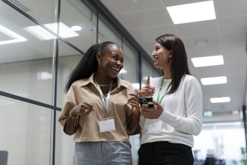 Two businesswomen walking together in office corridor