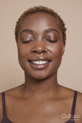 Studio portrait of smiling woman with nose ring and eyes closed