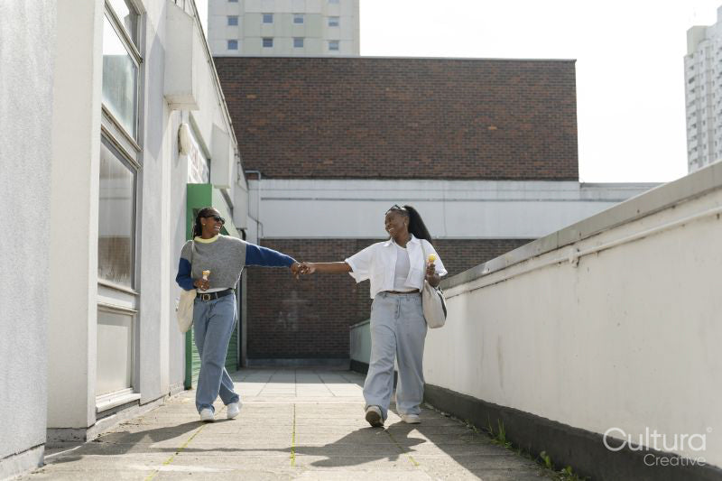 Young female couple walking in city and holding hands