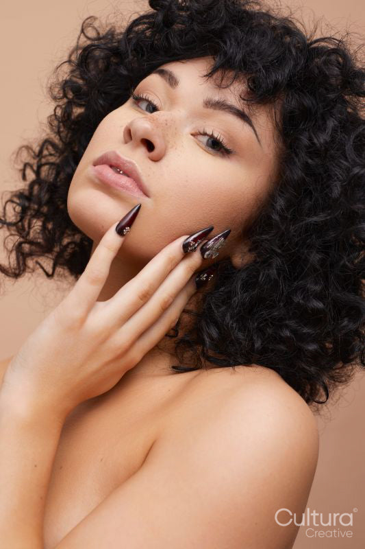 Studio portrait of beautiful serious woman with colored nails