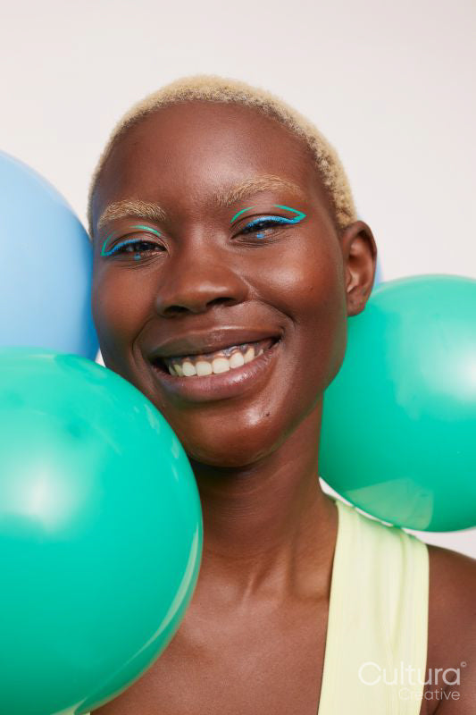 Portrait of smiling woman with short white hair and balloons