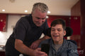 Father using smartphone with disabled son at home
