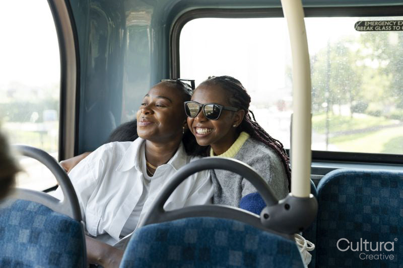 Young female friends riding city bus