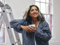Smiling woman having coffee break during renovation