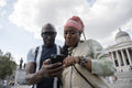 Happy mature couple using smartphone while visiting city
