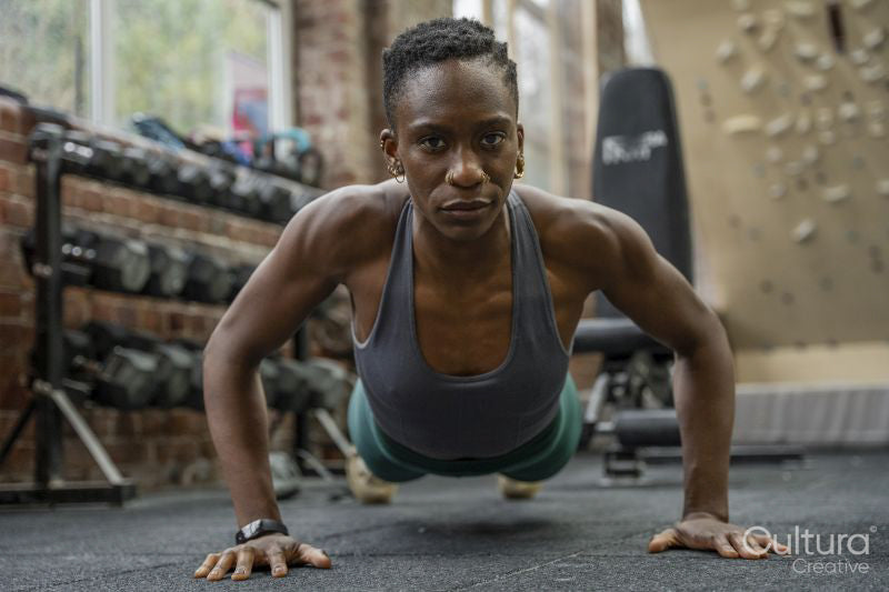 Athletic woman doing push-ups at gym