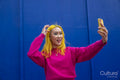 Young woman with yellow hair taking selfie outdoors