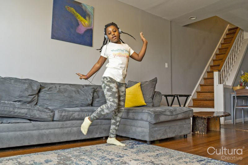 Girl with headphones dancing in living room