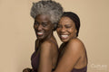 Studio portrait of two laughing women wearing lingerie