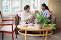 Senior woman knitting and talking to care giver in nursing home