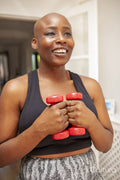 Mature woman exercising at home with dumbbells