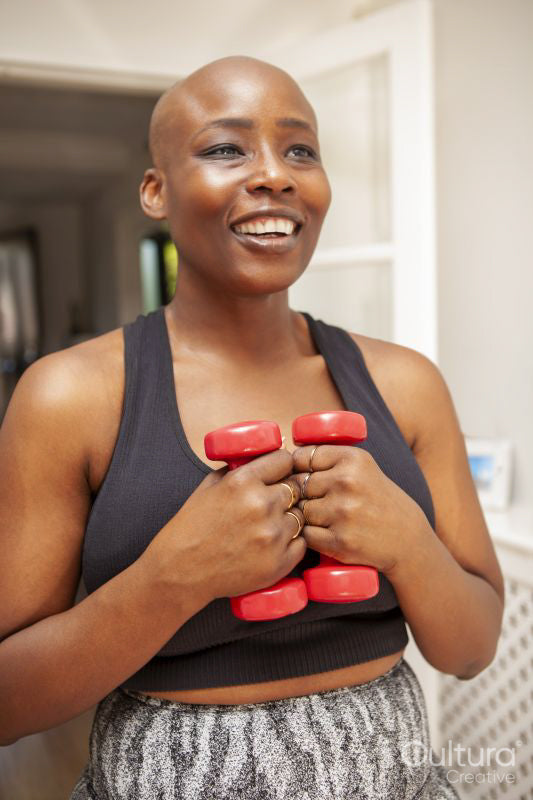 Mature woman exercising at home with dumbbells