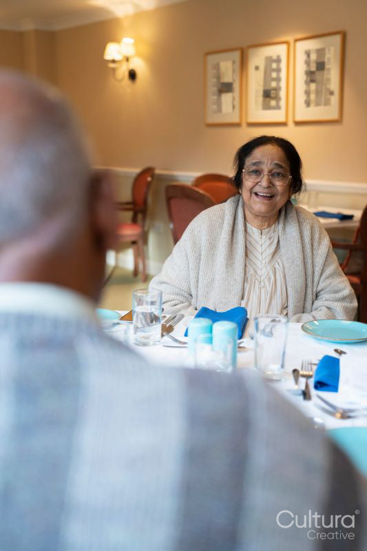 Senior woman and man sitting at table during meal in nursing home