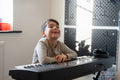 Boy playing music keyboard at home