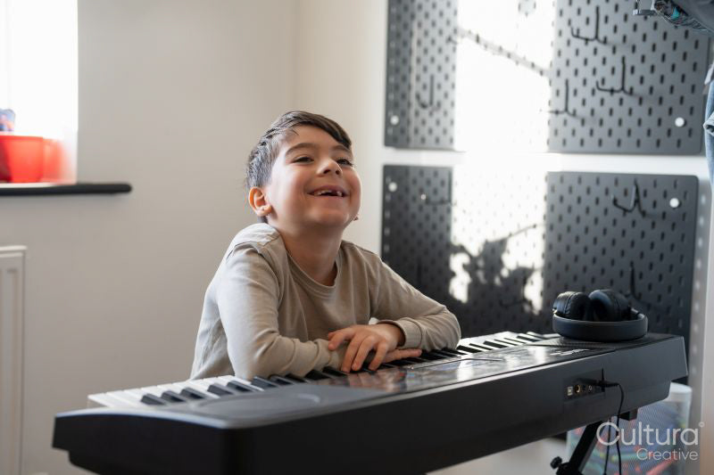 Boy playing music keyboard at home