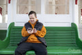Man sitting on bench and using smart phone