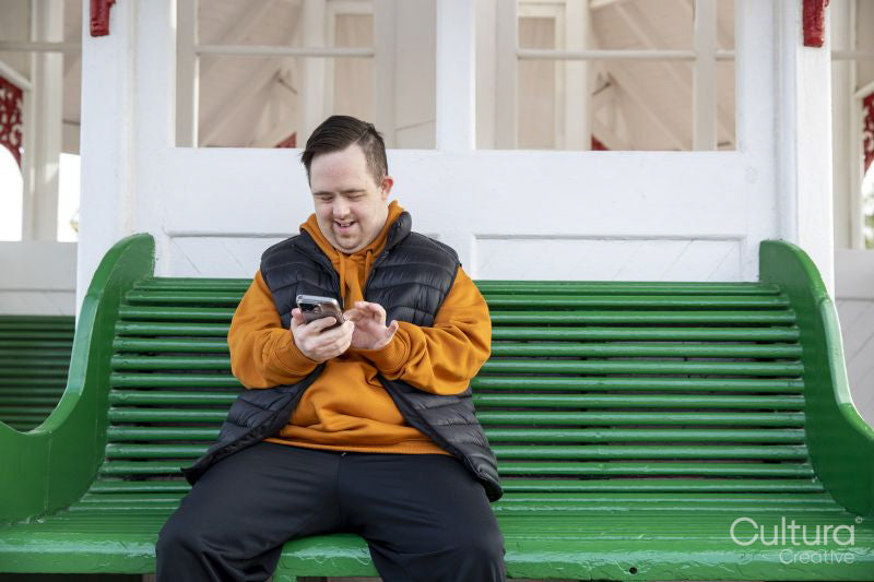 Man sitting on bench and using smart phone