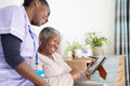 Smiling caregiver and senior woman looking at photography