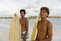 Indonesia, Lombok, Portrait of two surfers standing on beach