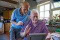 Senior male couple having video call on tablet