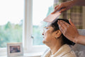 Nurse brushing hair of senior lady at nursing home