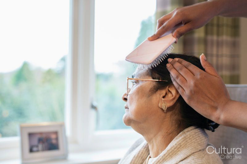 Nurse brushing hair of senior lady at nursing home