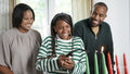 Family with daughter lighting kinara candles
