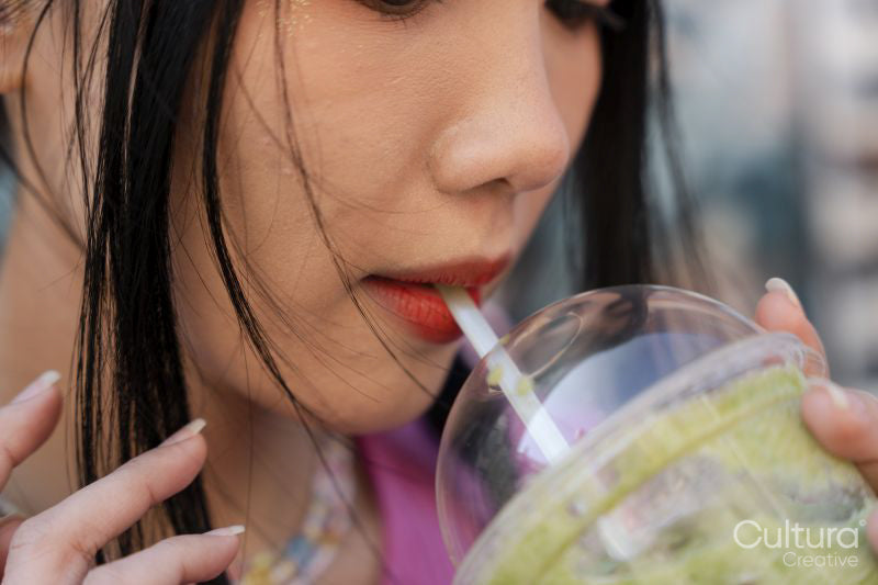 Close-up of young woman drinking sweet drink
