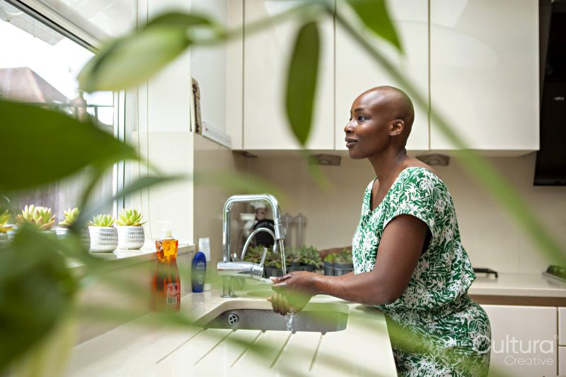 Woman washing hands in kitchen sink