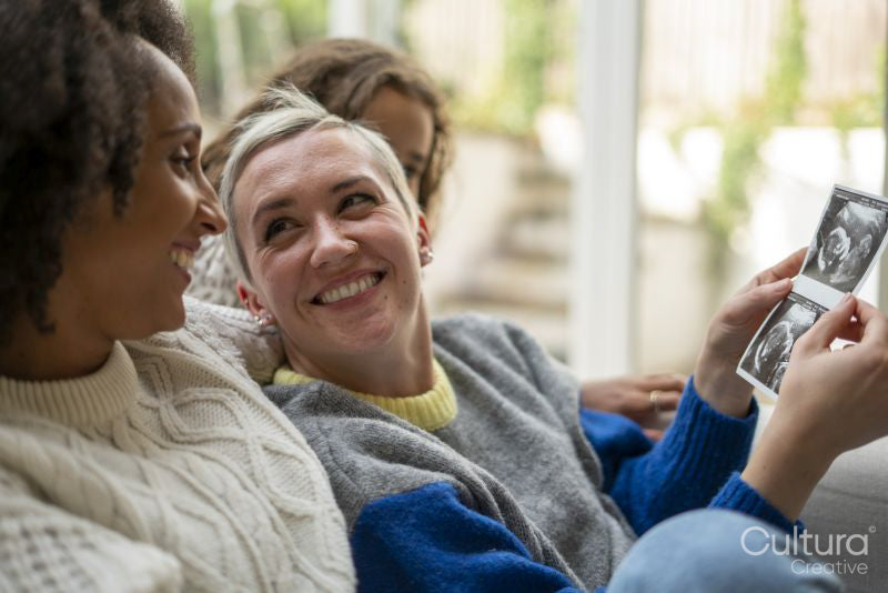 Smiling couple looking at baby ultrasound image