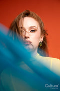 Woman in a yellow dress veiled by blue sheer fabric
