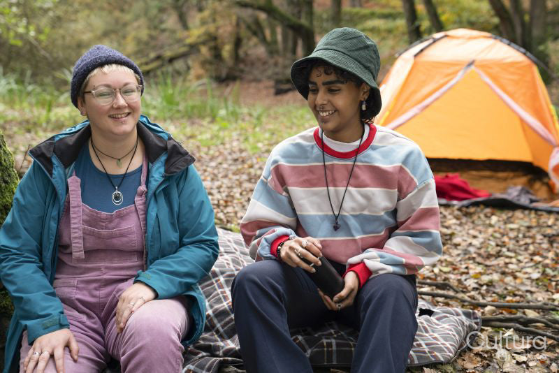 Smiling female friends camping in forest