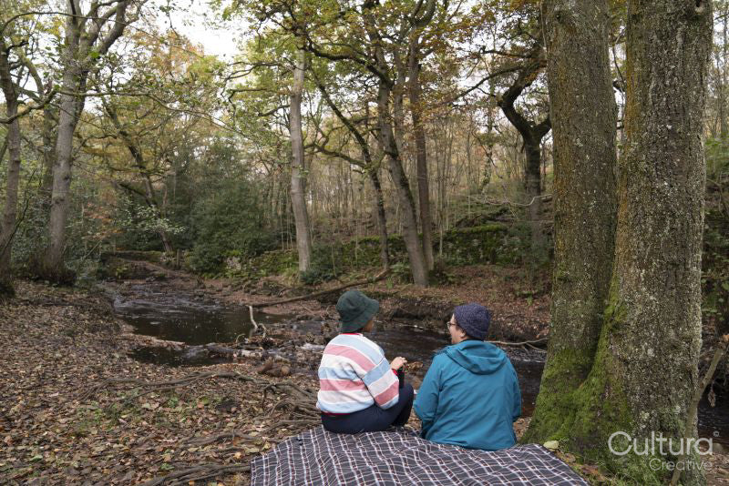 Female friends relaxing in forest by river