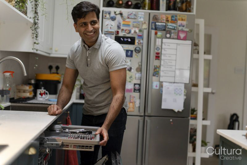 Man putting dishes into dishwasher