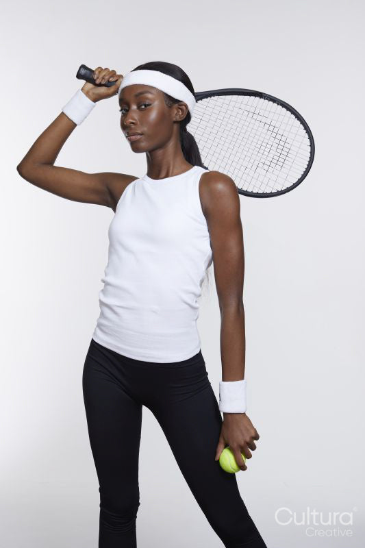 Studio portrait of athletic woman with tennis racket and ball