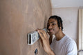 Teenage boy using spirit level on wall
