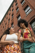 Two women in front of brick building, low angle view