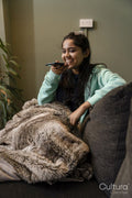 Young woman sitting on sofa and using phone