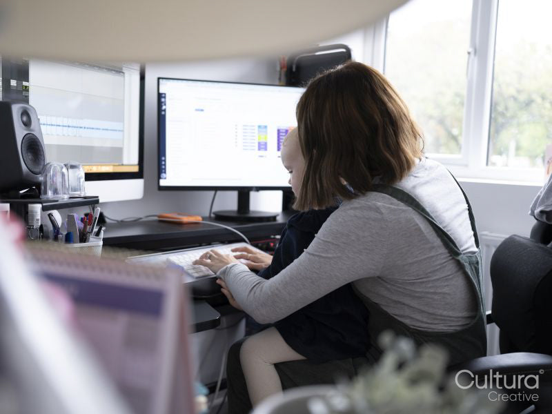 ZLY RELEASE Mother and daughter sitting at desk and using desktop pc at home