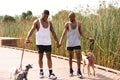 Louisiana, couple walking on boardwalk with dogs