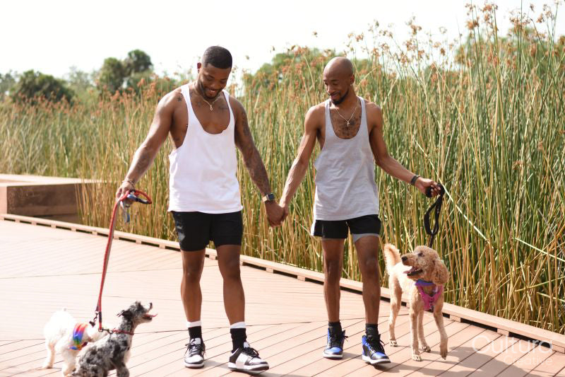Louisiana, couple walking on boardwalk with dogs