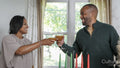 Mature couple raising toast during Kwanzaa meal