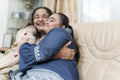 Portrait of grandmother embracing granddaughter in living room