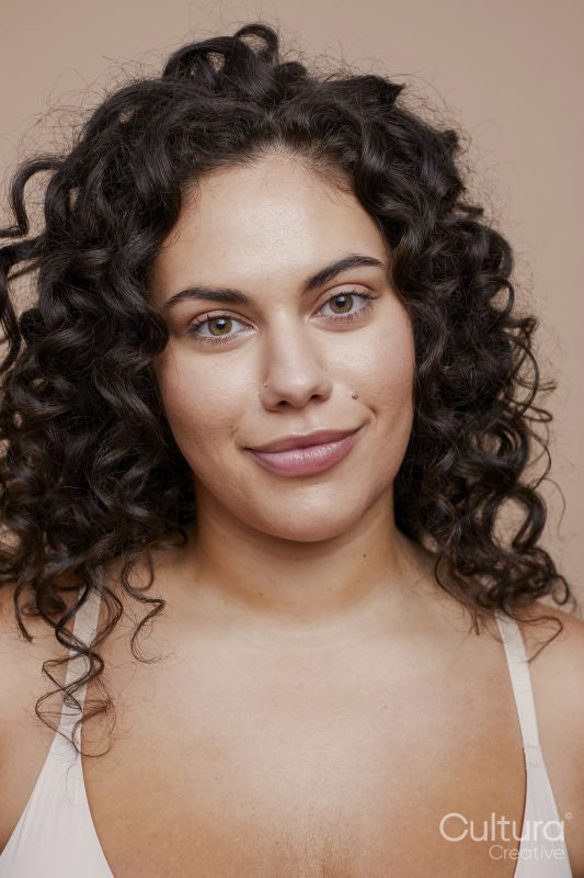Studio portrait of young woman with curly hair