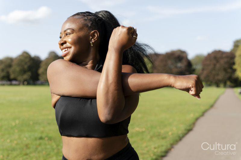 Young woman stretching in park